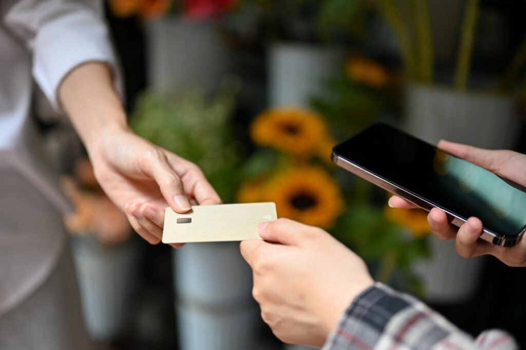 An Asian female customer paying her stuff with a credit card. Credit card payment concept. cropped image